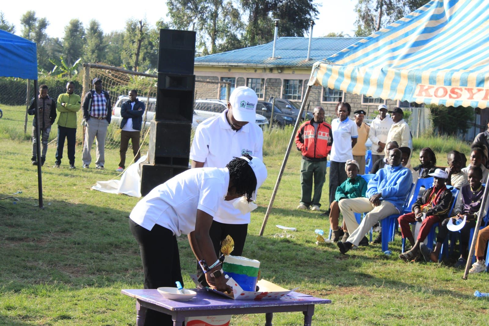 Cutting the launch cake as the community looks on in Sachangwan
